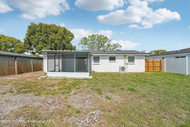 rear view of house with a fenced backyard, a sunroom, stucco siding, ac unit, and a lawn