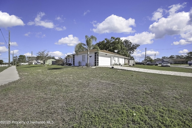 view of yard featuring driveway and a garage