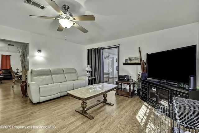 living area with visible vents, wood finished floors, and a ceiling fan