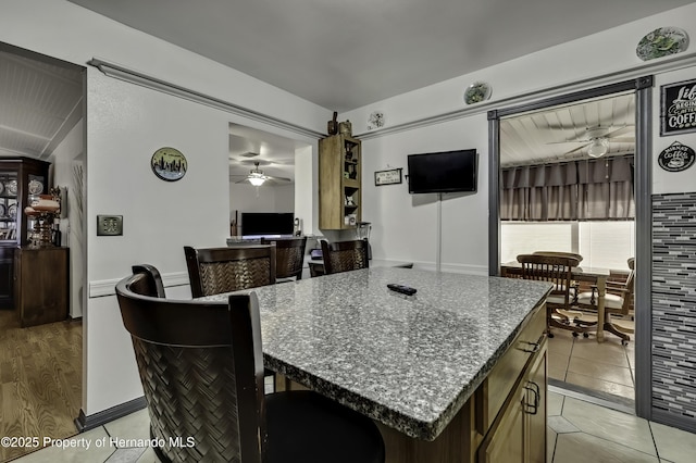 interior space featuring light tile patterned flooring and ceiling fan