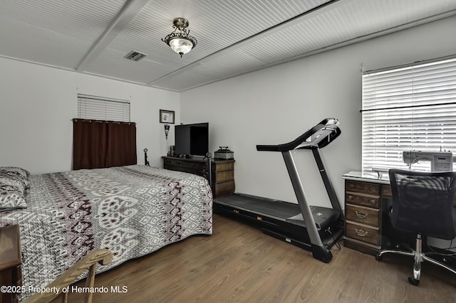 bedroom featuring visible vents and wood finished floors