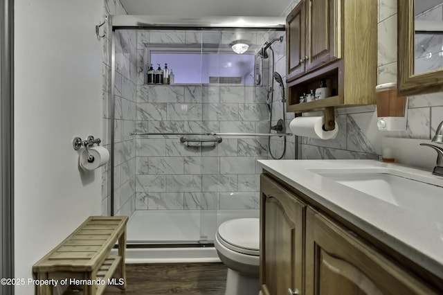 bathroom with vanity, toilet, tasteful backsplash, and a stall shower