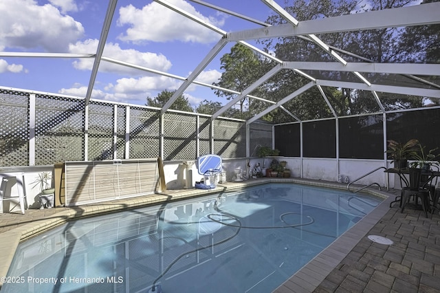 view of pool featuring glass enclosure and a patio area