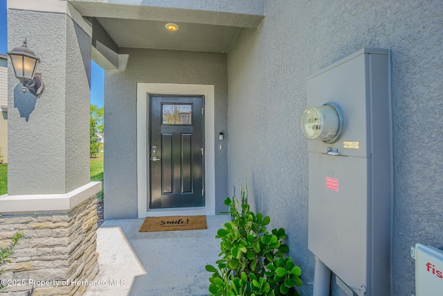 doorway to property featuring stucco siding