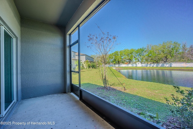 unfurnished sunroom featuring a water view