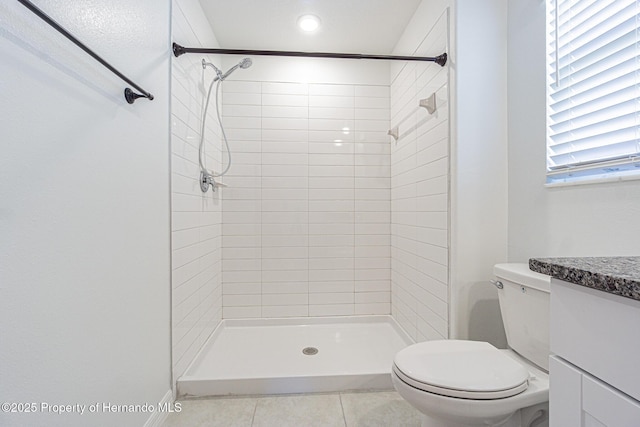 full bathroom featuring tile patterned floors, tiled shower, toilet, and vanity