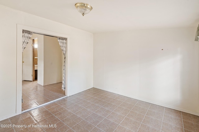 unfurnished room featuring baseboards