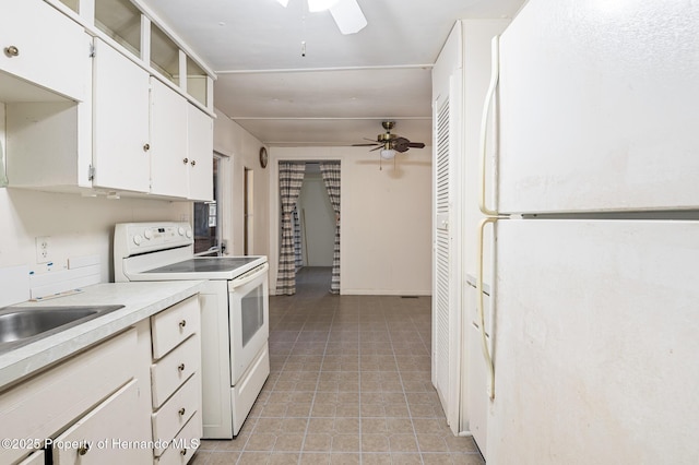 kitchen with white appliances, light tile patterned floors, ceiling fan, light countertops, and white cabinetry