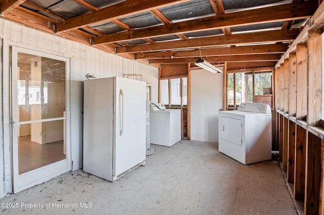 below grade area featuring washer / clothes dryer and freestanding refrigerator