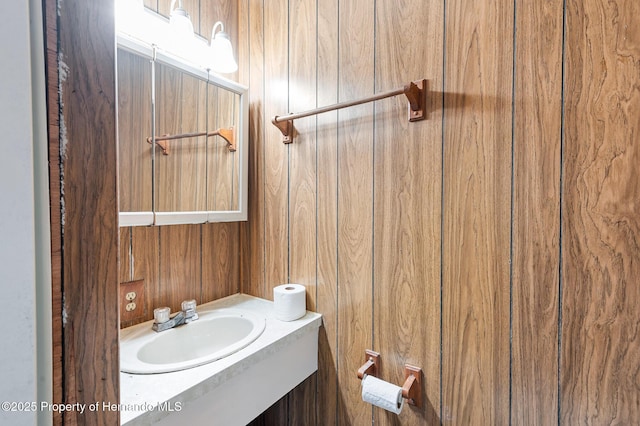 bathroom featuring wood walls and vanity