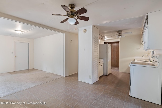 unfurnished room featuring ceiling fan, washer / clothes dryer, and light carpet