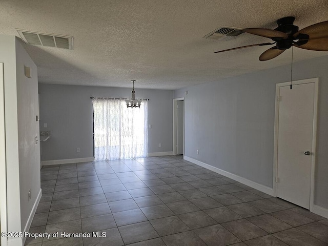 tiled spare room with visible vents, ceiling fan with notable chandelier, a textured ceiling, and baseboards