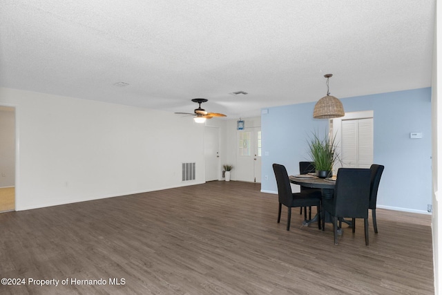 dining room with visible vents, a ceiling fan, a textured ceiling, wood finished floors, and baseboards