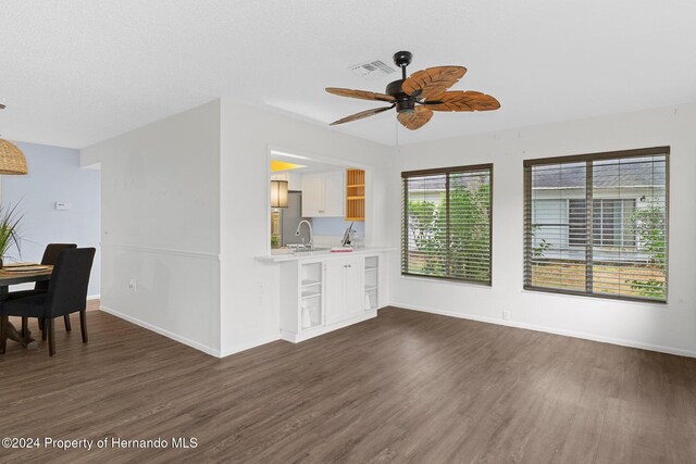 living room featuring visible vents, baseboards, dark wood finished floors, a textured ceiling, and a ceiling fan