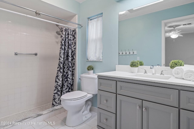 bathroom with toilet, a tile shower, tile patterned floors, vanity, and a ceiling fan