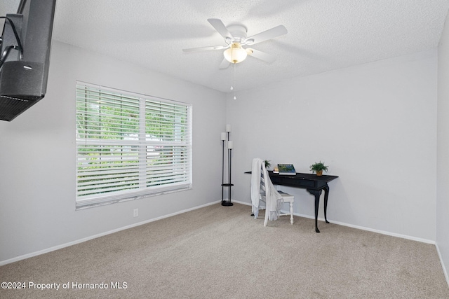 home office with baseboards, carpet floors, a textured ceiling, and a ceiling fan