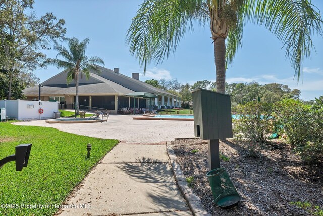 view of community with a lawn and fence