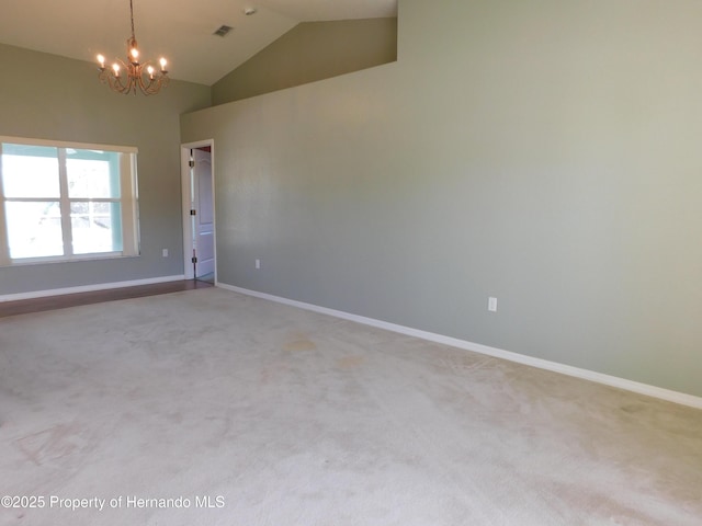 empty room with baseboards, light colored carpet, an inviting chandelier, and high vaulted ceiling