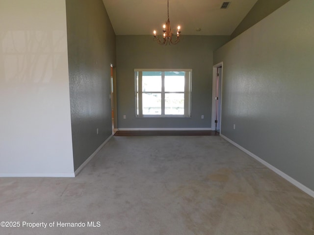 carpeted spare room featuring an inviting chandelier, baseboards, and vaulted ceiling