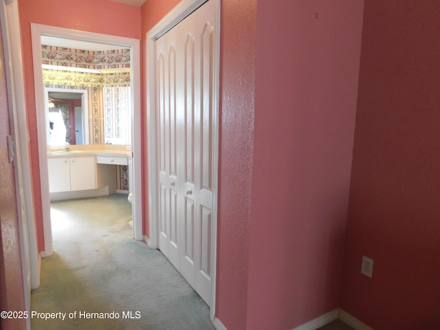 corridor with baseboards and carpet floors