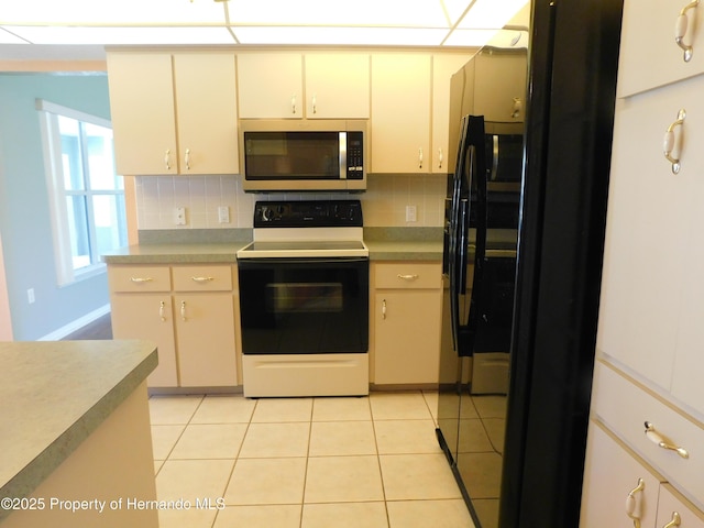 kitchen featuring light tile patterned floors, stainless steel microwave, decorative backsplash, and electric range oven