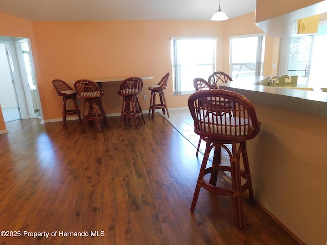 dining space with dark wood-type flooring and baseboards