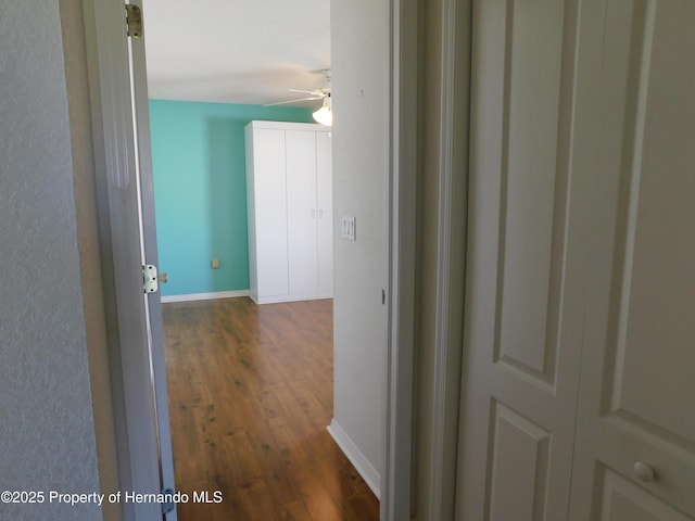 hall featuring baseboards and wood finished floors