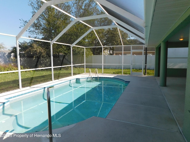 view of swimming pool featuring glass enclosure, a patio, a fenced backyard, and a fenced in pool