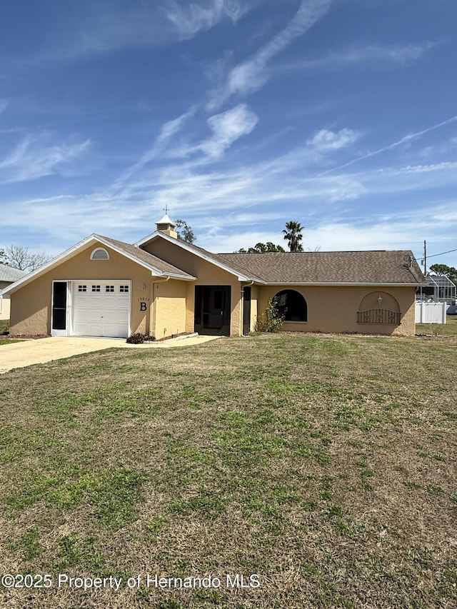 single story home featuring stucco siding, a front yard, concrete driveway, and an attached garage