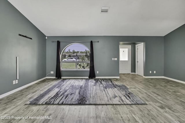 foyer with wood finished floors, visible vents, and baseboards