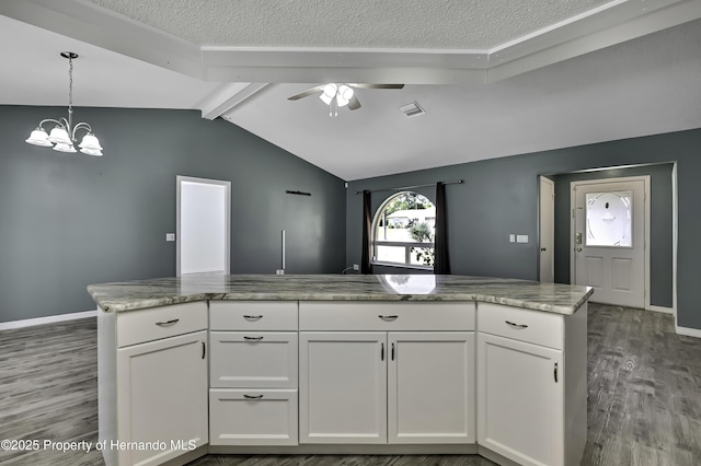 kitchen featuring wood finished floors, vaulted ceiling with beams, white cabinetry, and ceiling fan with notable chandelier