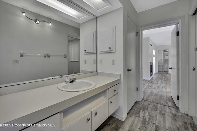 bathroom featuring baseboards, vanity, and wood finished floors