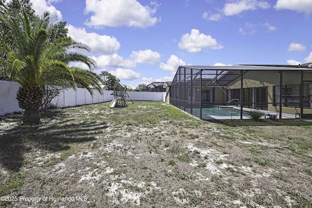 view of yard with glass enclosure, a fenced in pool, a fenced backyard, and a playground