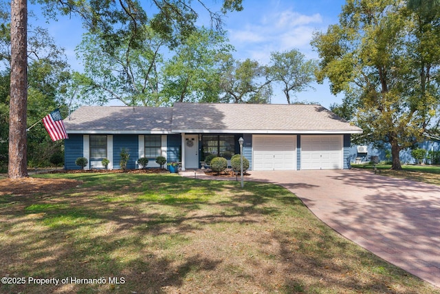 view of front of house featuring concrete driveway, a garage, a front yard, and roof with shingles