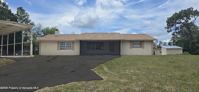 16402 Killearn Ln, Spring Hill Pasco, FL 34610 - view of front of home featuring a chimney, a front yard, asphalt driveway, and an outdoor structure