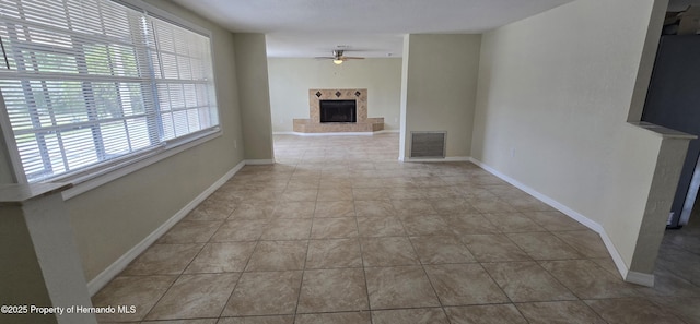 16402 Killearn Ln, Spring Hill Pasco, FL 34610 - unfurnished living room featuring ceiling fan, a tiled fireplace, baseboards, and tile patterned flooring