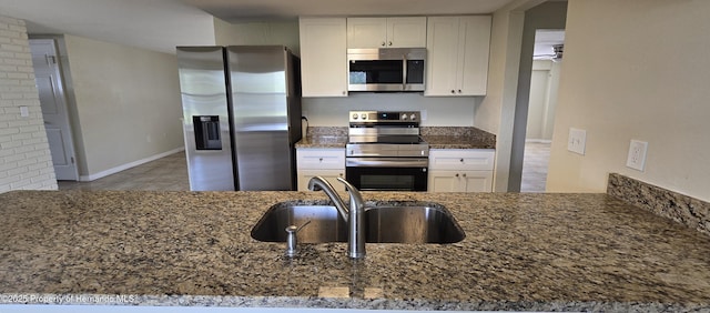 16402 Killearn Ln, Spring Hill Pasco, FL 34610 - kitchen with stainless steel appliances, a sink, dark stone countertops, white cabinets, and tile patterned floors