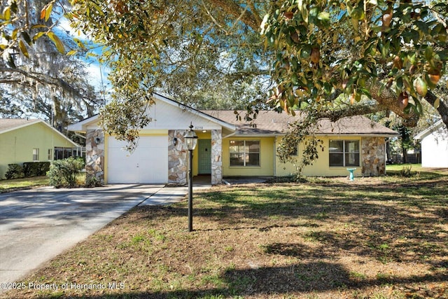 ranch-style house featuring concrete driveway, an attached garage, stone siding, and a front lawn