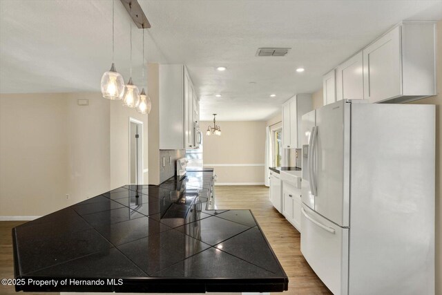 kitchen featuring visible vents, electric range, white refrigerator with ice dispenser, white cabinets, and light wood finished floors