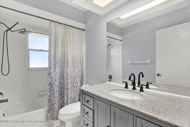 bathroom with vanity, toilet, and shower / bath combo with shower curtain