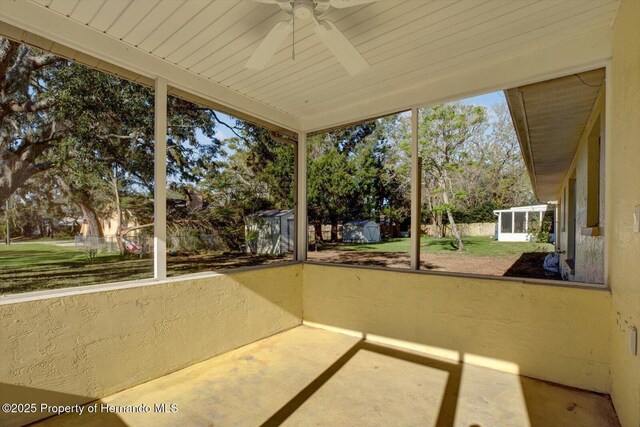 view of patio with fence, a storage shed, ceiling fan, and an outdoor structure