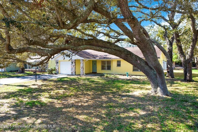 ranch-style home with a front lawn and an attached garage