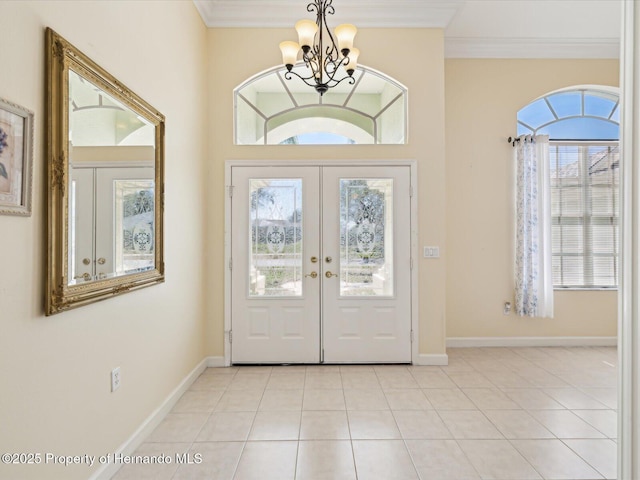 foyer entrance with ornamental molding, baseboards, light tile patterned floors, and a chandelier