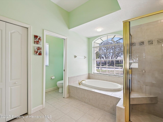 full bath with baseboards, a stall shower, tile patterned flooring, a garden tub, and toilet