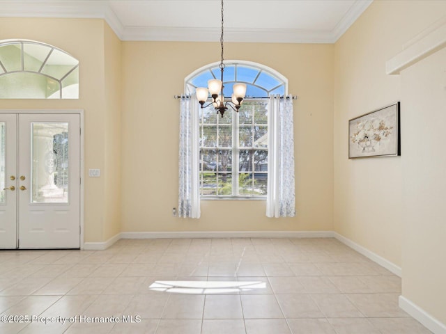 tiled foyer featuring baseboards, a notable chandelier, and crown molding