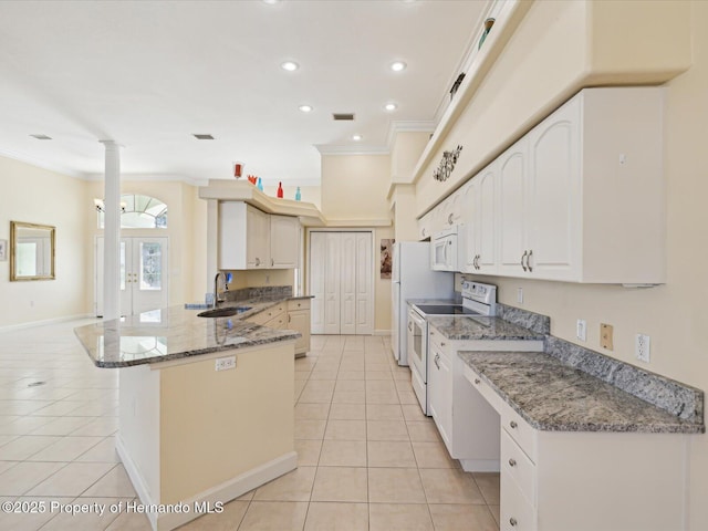 kitchen with crown molding, a peninsula, light tile patterned flooring, white appliances, and ornate columns