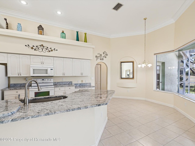 kitchen with white appliances, light stone countertops, a sink, hanging light fixtures, and crown molding