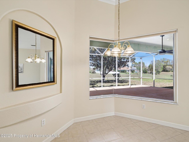 unfurnished dining area with tile patterned floors, ceiling fan with notable chandelier, and baseboards