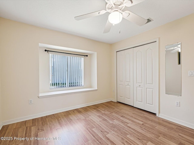 unfurnished bedroom with a closet, light wood-type flooring, and baseboards