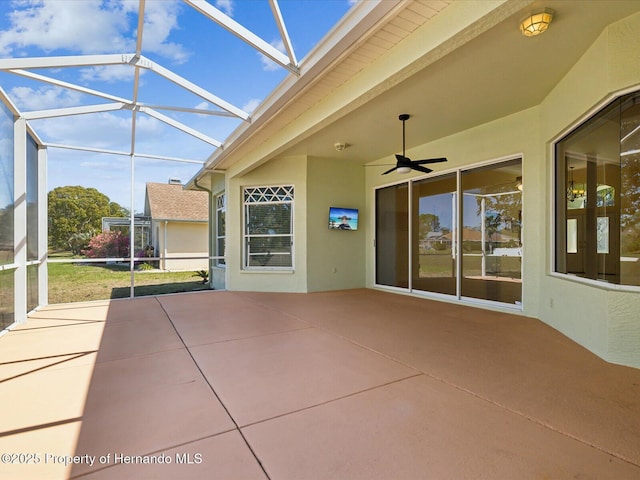 view of patio featuring glass enclosure and ceiling fan